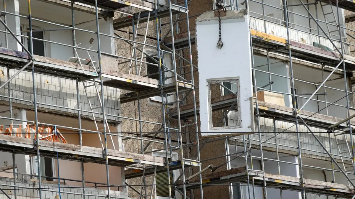 Kopfstrasse Abriss Balkone: In der Kopfstrasse hat der Abriss der Balkone begonnen. Nachdem die Arbeiter die einzelnen Platten aus der Verankerung gelöst haben, werden sie mit Hilfe eines Autodrehkrans, der auf der Rückseite des Wohnblocks steht, zu Boden gelassen.