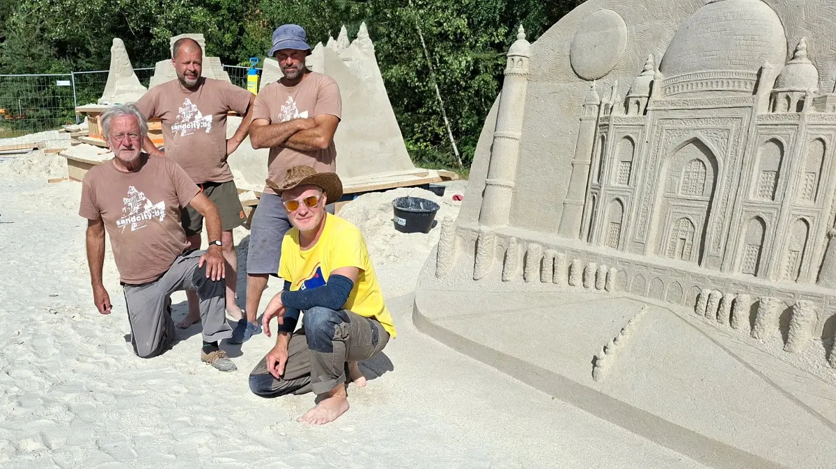 Die Künstlergruppe von Sandcity um Benno Lindel (l.) vor ihren Sandskulpturen am Rückersdorfer See.