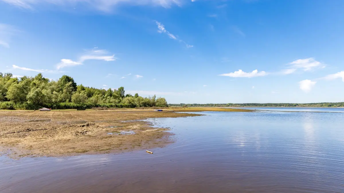 Sommerliches Wetter - Niedrigwasser an der Spree: 29.07.2026, Brandenburg, Bagenz: Das Wasser in der Talsperre Spremberg ist deutlich zurückgegangen - an den Badestränden werden die Uferbereiche immer breiter. Um die verbliebenen Reserven in den Wasserspeichern besser managen zu können und die Niedrigwasserstützung bis zum Ende des Sommers zu sichern, hat das Landesamt für Umwelt (LfU) Brandenburg eine länderübergreifende Ad-hoc-Arbeitsgruppe einberufen. Foto: Frank Hammerschmidt/dpa +++ dpa-Bildfunk +++