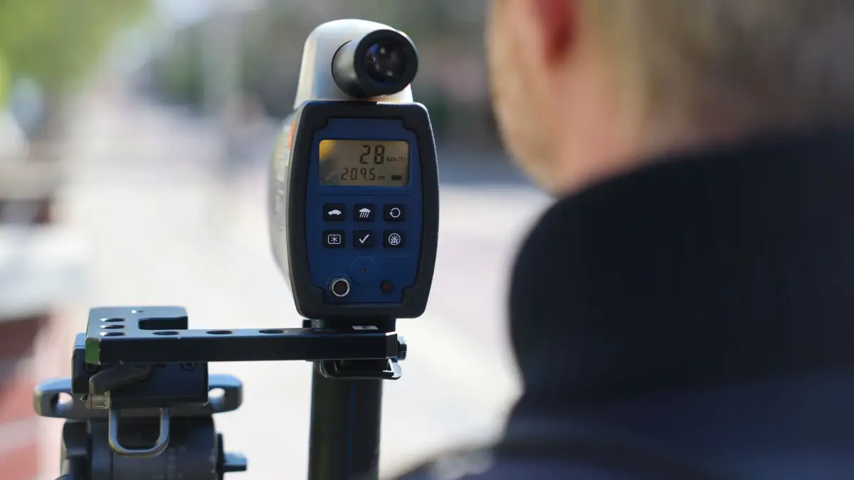 Geschwindigkeitskontrollen in Sachsen-Anhalt: ARCHIV - 15.04.2026, Sachsen-Anhalt, Halle: Ein Polizist misst mit einer Laserpistole die Geschwindigkeit von Autofahrern. (zu dpa: «Polizei kontrolliert verstärkt die Geschwindigkeit») Foto: Jan Woitas/dpa +++ dpa-Bildfunk +++