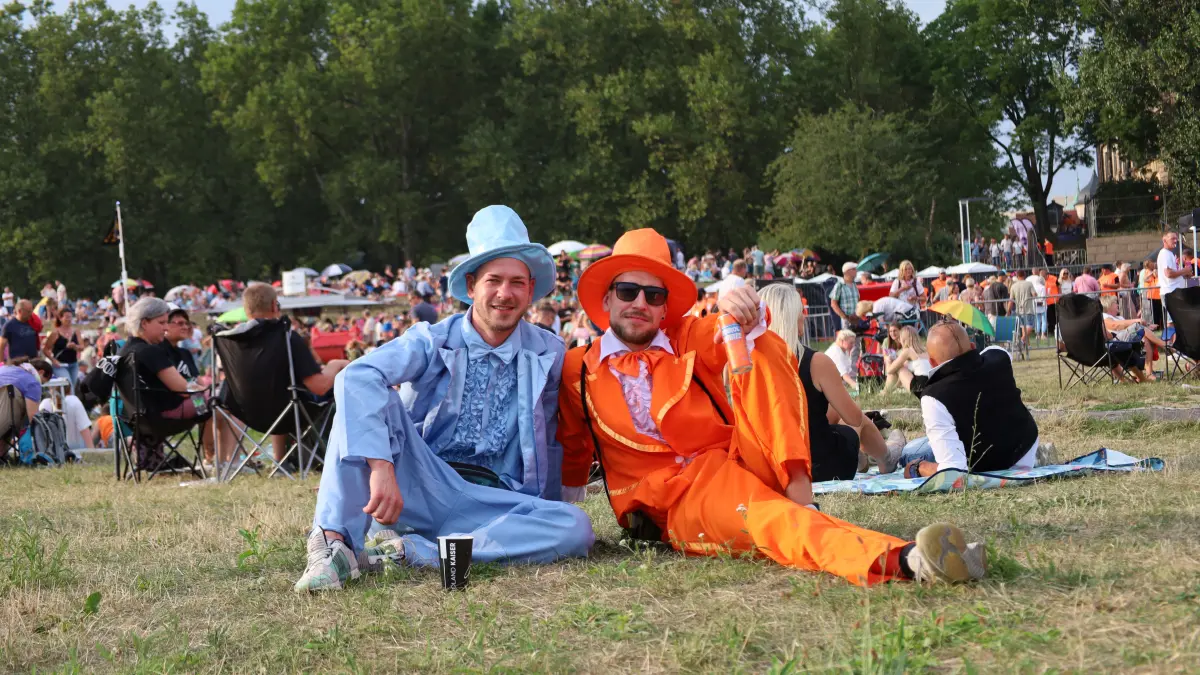 Zwei Freunde haben sich bunte Kostüme für das Konzert herausgesucht.