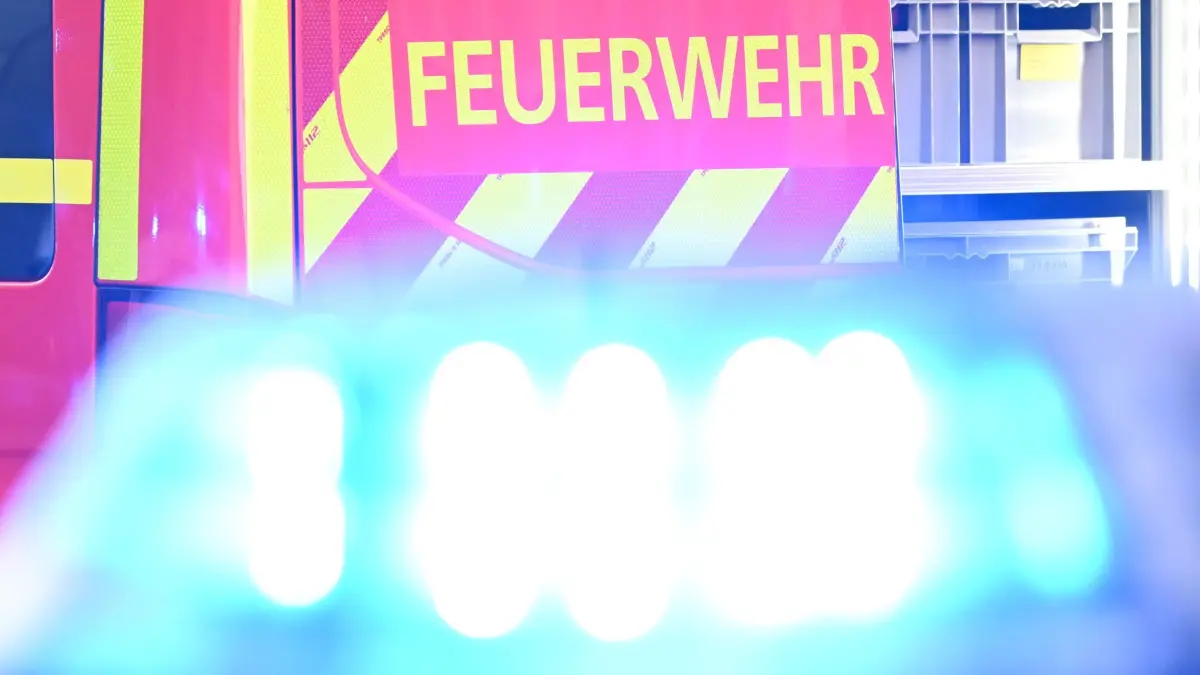 Feuerwehr: ARCHIV - 02.05.2025, Baden-Württemberg, Stuttgart: Ein Fahrzeug der Feuerwehr steht bei einem Einsatz auf einer Straße, während im Vordergrund das Blaulicht eines Polizeifahrzeugs zu sehen ist. (zu dpa: «Zwischendecke im Bürogebäude eingestürzt – Zwei Verletzte») Foto: Bernd Weißbrod/dpa +++ dpa-Bildfunk +++