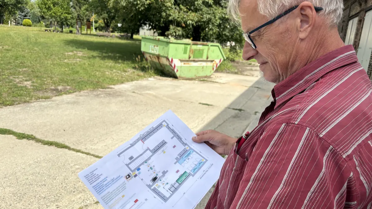 Ortsvorsteher Frank Müller zeigt den Plan, wie das neue Geschäft in Reichwalde aussehen soll.