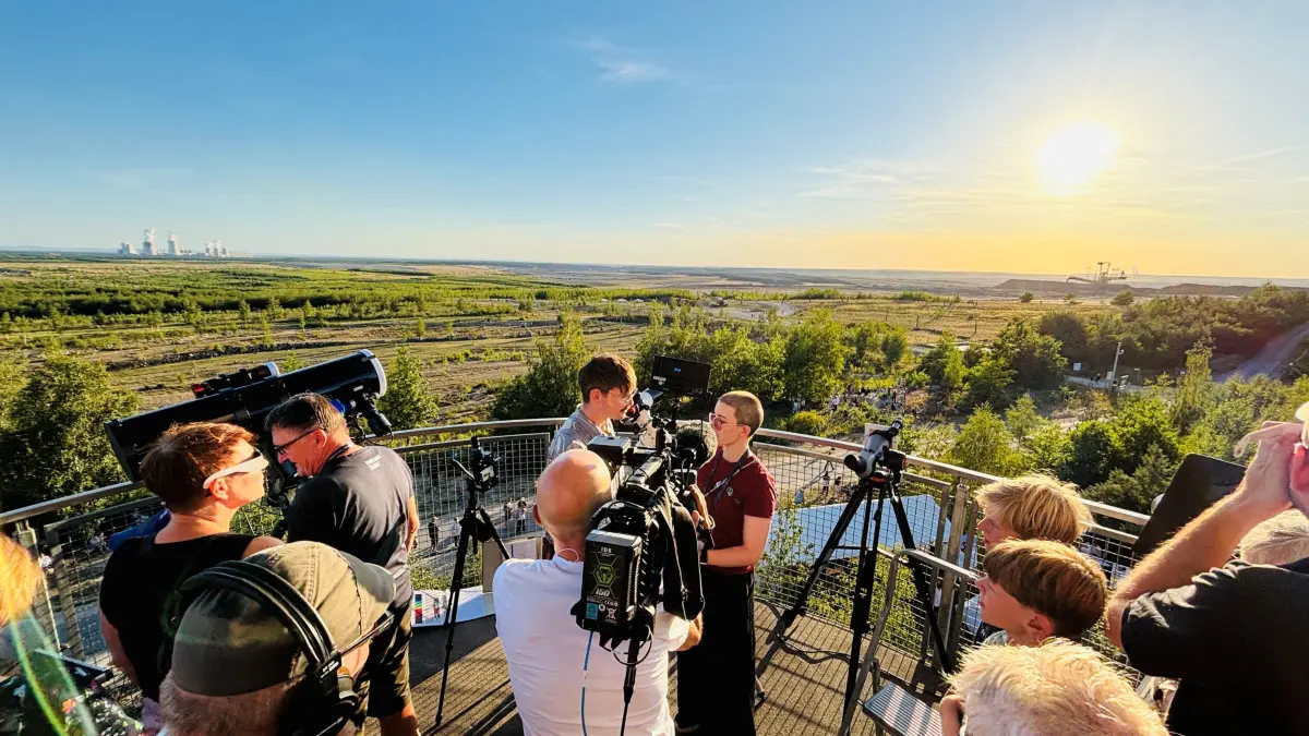 Während sich der Mond langsam vor die Sonne schiebt, gibt die Biologin Jana Bingemeier auf dem Turm am Schweren Berg bei Weißwasser ein Interview.