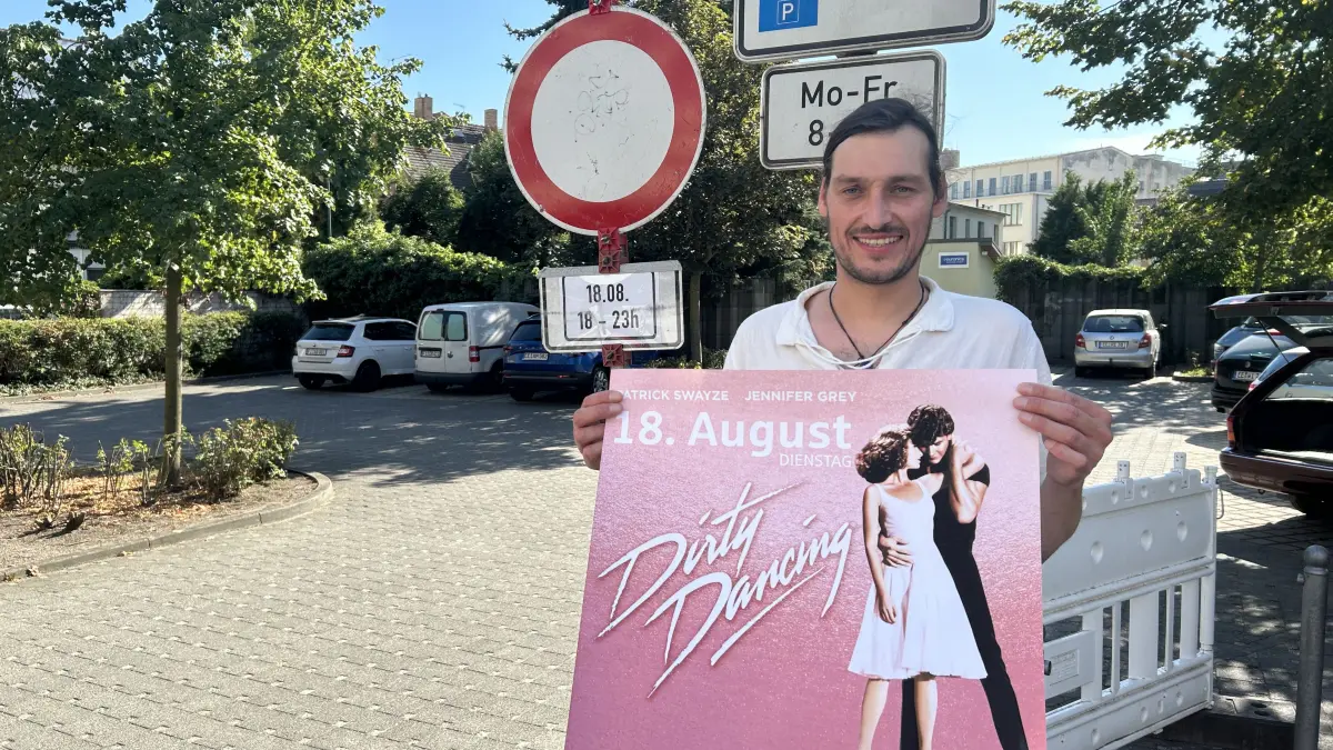 Max Siegert wirbt auf dem Parkplatz des Weltspiegels für den Open-Air-Abend mit „Dirty Dancing“. Das Besondere: Der Kultfilm wird auf alter DDR-Kinotechnik gezeigt.