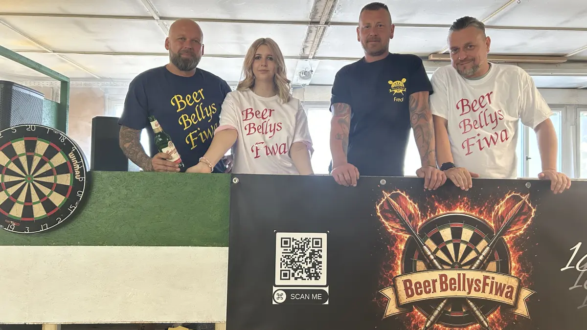 Die Beer Bellys (Jens und Annabell Richter sowie Fred Diller und Sven Hartung, v.l.) posieren auf ihrem Wagen fürs Sängerfest 2026. Mit Darts, Bier und Nebel kündigt der junge Verein aus Finsterwalde einen Auftritt an, der beim Festumzug am Sonntag ordentlich Wirbel machen dürfte.