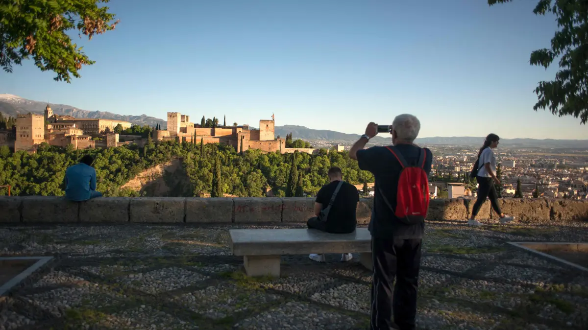 FILES-SPAIN-EARTHQUAKE-MONUMENT: (FILES) A man takes pictures of the Alhambra from Saint Nicholas square in Granada, on May 2, 2020. Spain's cherished tourist hotspot of Granada was in shock on August 15, 2026 after a rare 5.0-magnitude earthquake woke residents in the middle of the night and damaged buildings. But officials confirmed no casualties or serious damage, notably to the southern city's Alhambra palace, a UNESCO-listed jewel of medieval Islamic architecture and the seat of Spain's last Muslim kingdom. (Photo by JORGE GUERRERO / AFP)