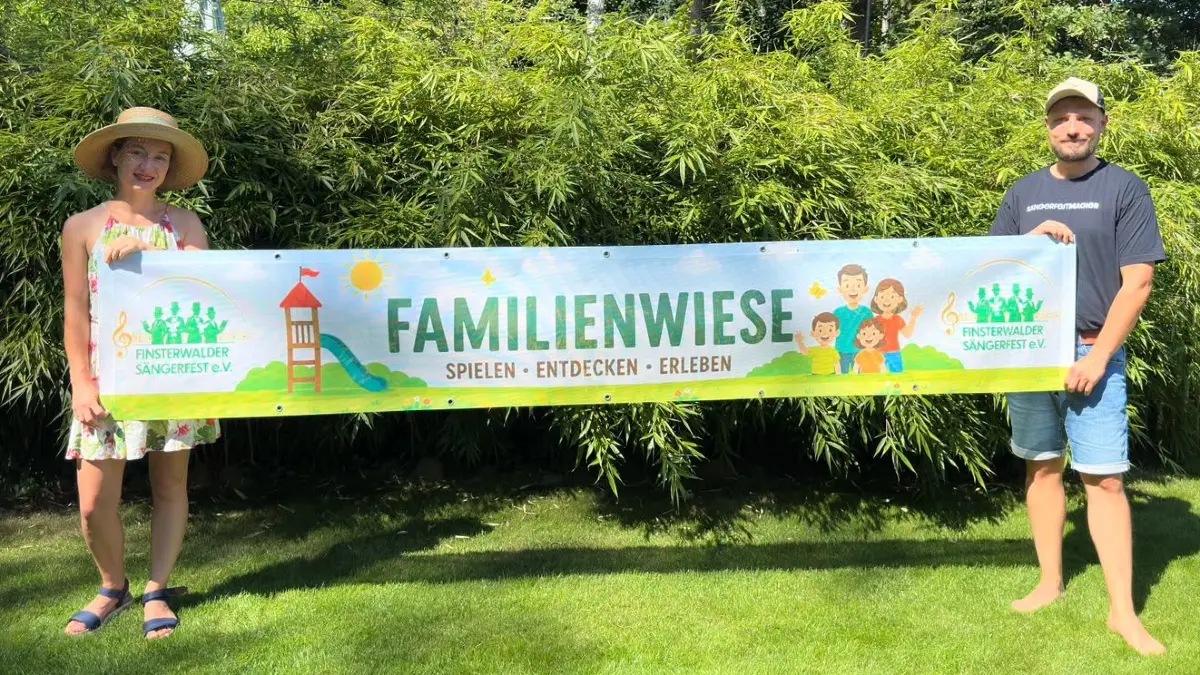 Lydia und Albert Hammitsch präsentieren ein Banner vom neuesten Angebot beim Sängerfest. Im Schlosspark wird eine Familienwiese aufgebaut - mit vielen Angeboten für Eltern und Kinder.
