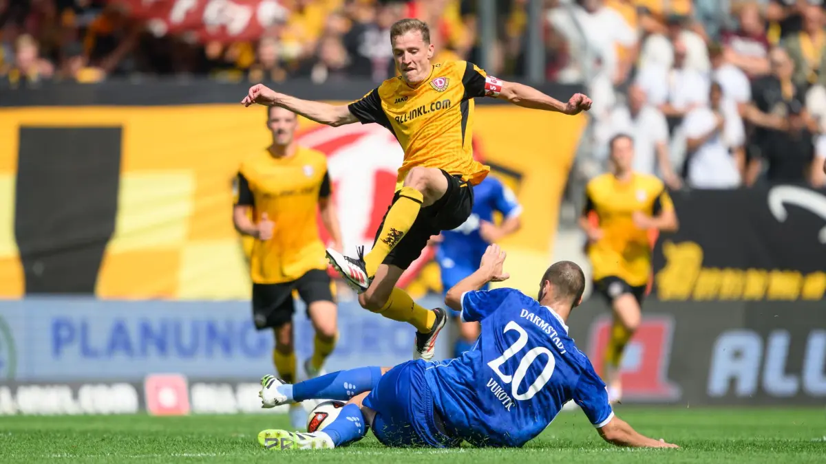 SG Dynamo Dresden - SV Darmstadt 98: 16.08.2026, Sachsen, Dresden: Fußball, Männer: 2. Bundesliga, SG Dynamo Dresden - SV Darmstadt 98, 2. Spieltag, Rudolf-Harbig-Stadion, Niklas Hauptmann (Dynamo Dresden, l) gegen Aleksandar Vukotic (SV Darmstadt). Foto: Robert Michael/dpa - WICHTIGER HINWEIS: Gemäß den Vorgaben der Bundesliga bzw. des DFB Deutscher Fußball-Bund ist es untersagt, in dem Stadion und/oder vom Spiel angefertigte Fotoaufnahmen in Form von Sequenzbildern und/oder videoähnlichen Fotostrecken zu verwerten bzw. verwerten zu lassen. +++ dpa-Bildfunk +++