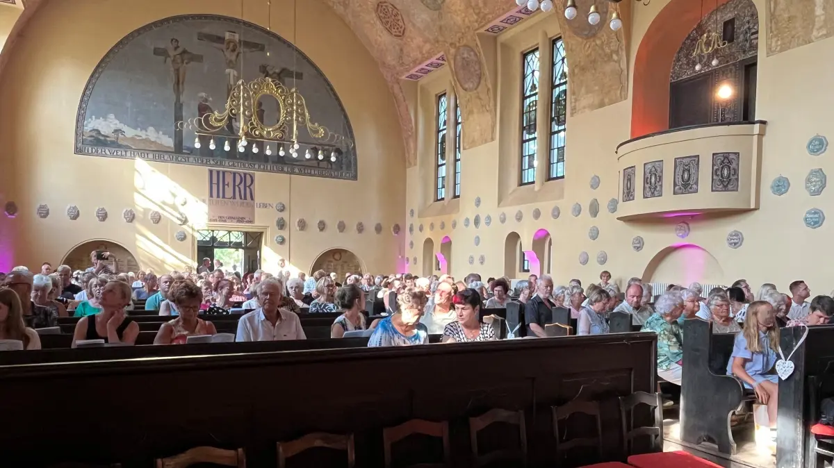 In der fast voll besetzten Jesus-Christus-Kirche entsteht ein Moment der Nähe, während die Herzenstour 2026 Station in Falkenberg/Elster macht.