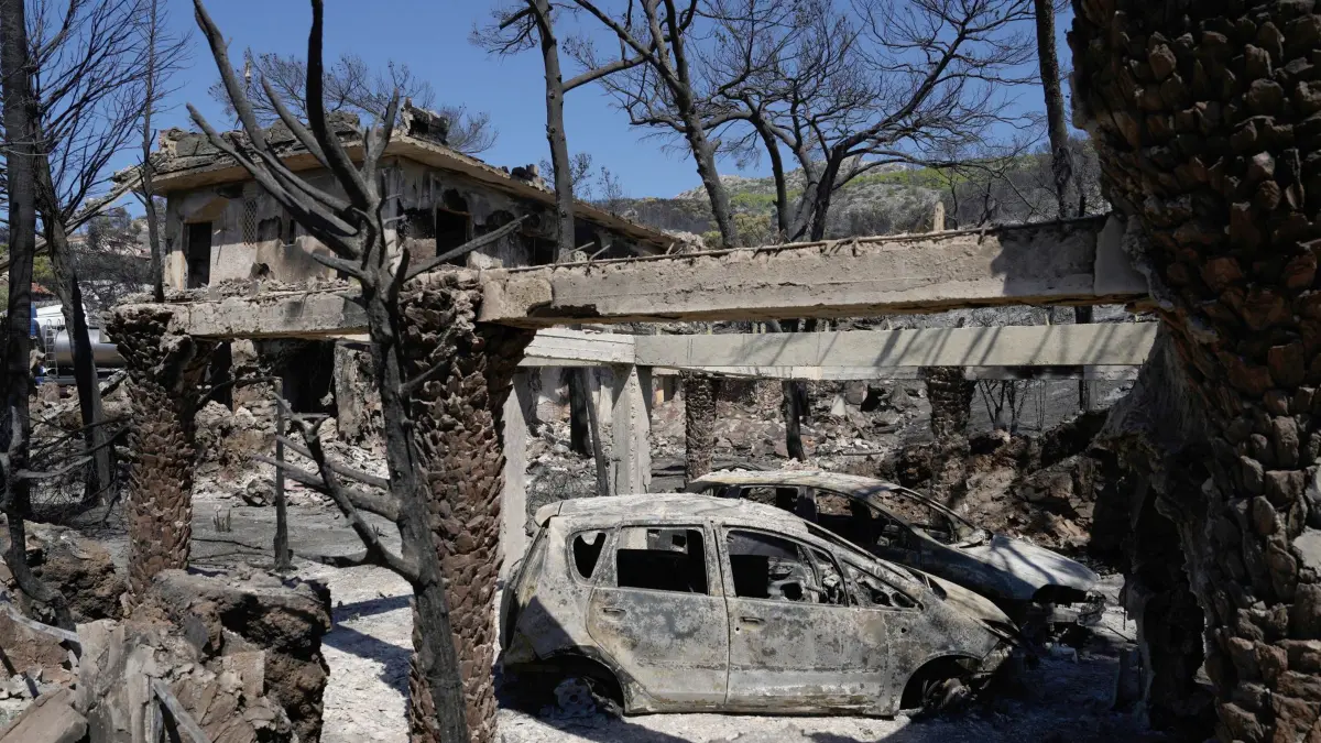Waldbrand auf griechischer Insel Salamis: 17.08.2026, Griechenland, Peristeria: Verbrannte Fahrzeuge und Bäume, aufgenommen einen Tag nach einem Waldbrand im Dorf Peristeria auf der Insel Salamis (Salamina). Bei dem Waldbrand sind zwei Menschen ums Leben gekommen. Foto: Thanassis Stavrakis/AP/dpa +++ dpa-Bildfunk +++