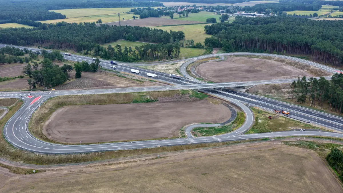 Luft Ortsumfahrung BAB 15 Freigabe: Luftaufnahme vom 19. August 2026
Freie Fahrt auf der "Trompete"Ein weiterer Meilenstein für
die Ortsumfahrung Cottbus
ist geschafft. Nach
knapp sechs Jahren Bauzeit
ist die neue Verbindung der
Bundesstraßen B168 und B97 mit
der Autobahn A15 bei Cottbus in der Nähe von Kahren am
Mittwoch für
den Verkehr freigegeben worden.
Autofahrer die neue Strecke nutzen.
Die Arbeiten am zweiten Teil
des zweiten Bauabschnitts, für die
neue B97, die die Bundesstraße
B168 mit der Autobahn A15 verbindet
und jetzt freigegeben wurde,
haben im Frühjahr 2025 begonnen.
Die drei Kilometer lange
Strecke umfasst mehrere Brücken,
wie die über die Ortsumgehung,
die Kahren und Koppatz miteinander
verbindet, und über die A15
für die Auf- und Abfahrten der
neuen Anschlussstelle Cottbus-
Ost. Die Ortsumfahrung Cottbus
gehört zu den größten Bauvorhaben
in der Region. Die Gesamtkosten
in Höhe von rund 50 Millionen
Euro werden aus dem Investitionsgesetz
Kohleregionen finanziert.
Dieses Geld stellt der Bund
zusätzlich zur Verfügung. Mit der
verbesserten Erschließung des
Oberzentrums Cottbus soll ein
wesentliches Projekt im Zusammenhang
mit dem Strukturwandel
umgesetzt werden.