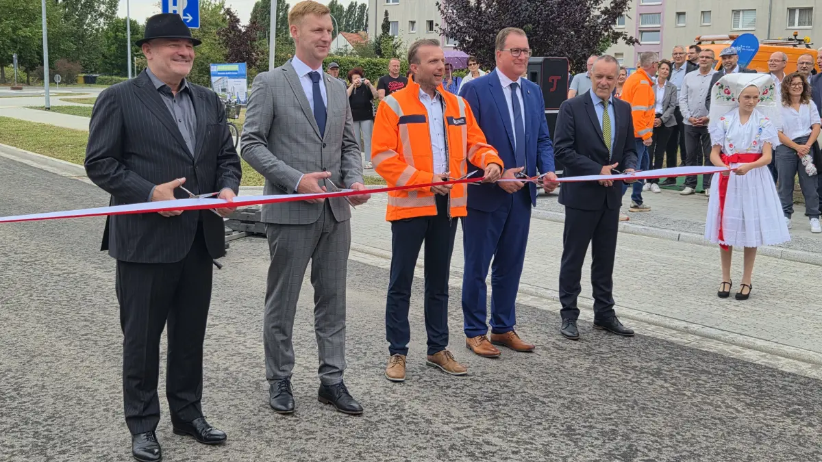 Flatterband in Stücke geschnitten wurde am Mittwoch (19. August 2026) auf der L54 in Vetschau. Die Schere beim symbolischen Schnitt in der Hand hatten: Infrastrukturminister Robert Crumbach (li.), Bürgermeister Chris Mielchen (2.v.li.), Mike Köhler (Mitte) und Steffen Kleiner (li.) vom Landesbetrieb Straßenwesen sowie Landrat Alexander Erbert (2.v.re.).