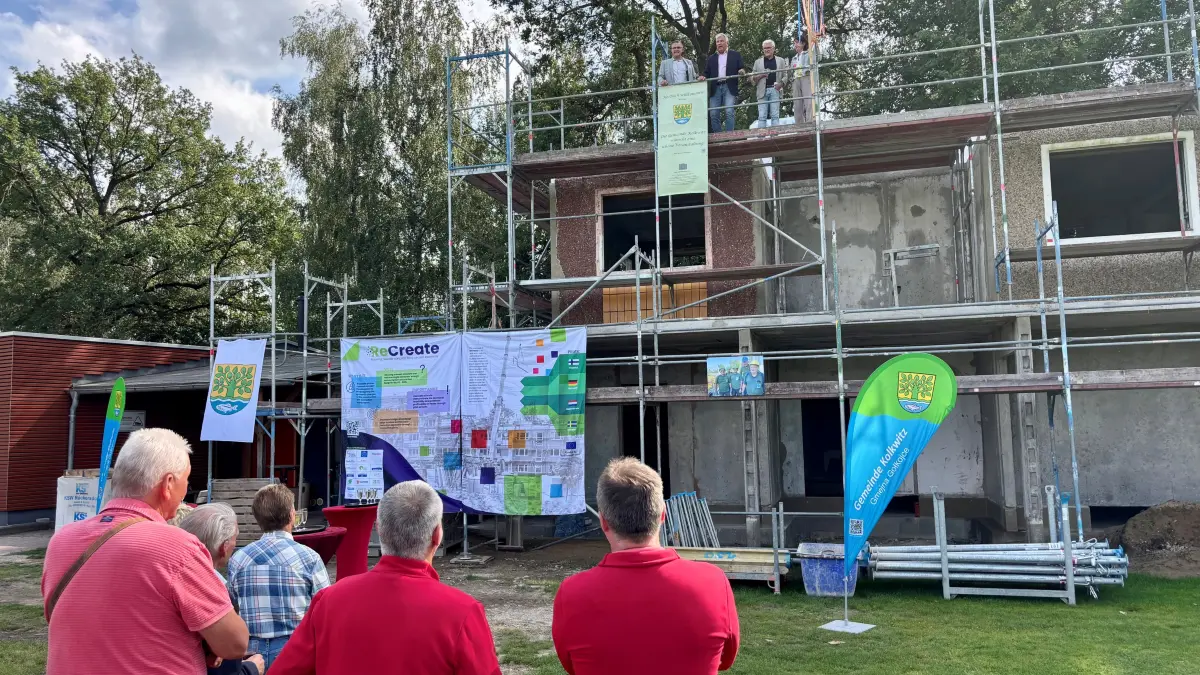 Das Richtfest für das neue Vereinsgebäude auf dem Friedrich-Ludwig-Jahn-Sportplatz in Kolkwitz wird am 20. August 2026 gefeiert. Das Besondere daran: Es wird aus alten Betonplatten eines DDR-Wohnblocks in Großräschen errichtet. Auf dem Gebäude (v.l.n.r.): der Bürgermeister Karsten Schreiber (SPD), der Lausitzbeauftragte der Landesregierung Klaus Freytag, Peter Jähne vom Cottbuser Planungsbüro Jähne und Angelika Mettke, Leiterin des Arbeitsgebiets Bauliches Recycling der BTU.