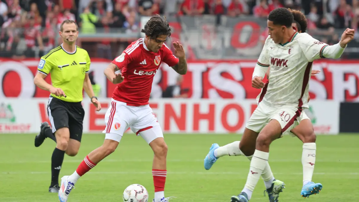 Fussball DFB-Pokal 1. Hauptrunde 2026/2027 FC Energie Cottbus - FC Augsburg: 9 Lucas Copado (Energie Cottbus, l.), 40 Nahkai Dominic Banks (FC Augsburg)