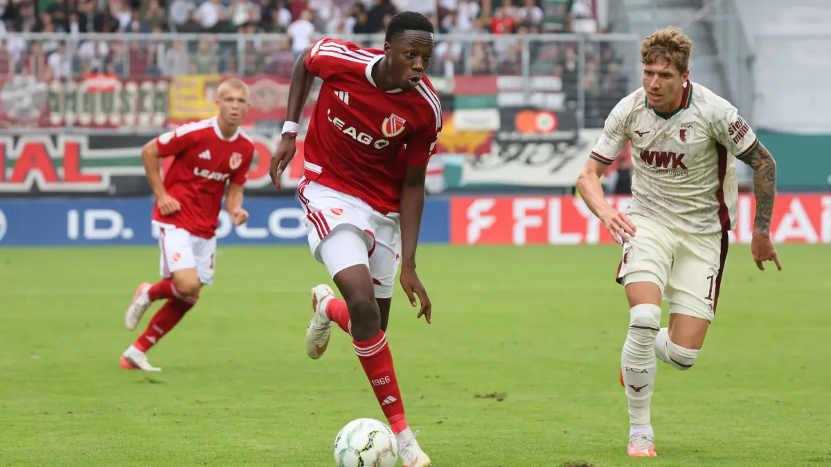 Fussball DFB-Pokal 1. Hauptrunde 2026/2027 FC Energie Cottbus - FC Augsburg: 2 King Manu (Energie Cottbus, l.), 17 Kristijan Jakic (FC Augsburg)