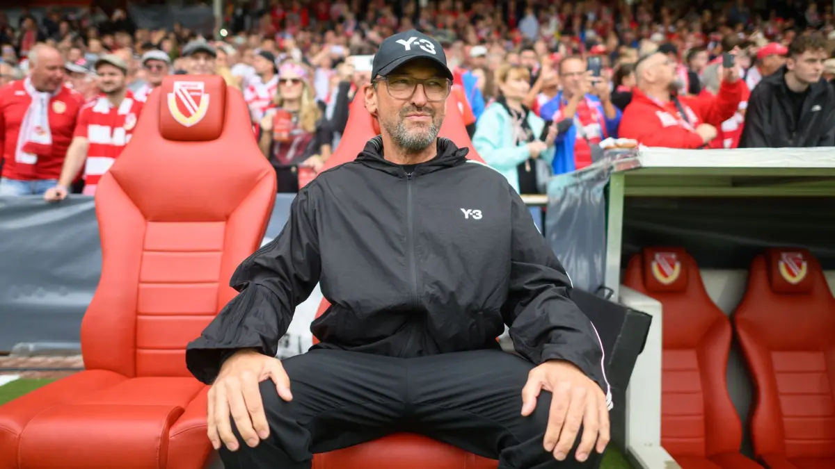 FC Energie Cottbus - FC Augsburg: 22.08.2026, Brandenburg, Cottbus: Fußball, Männer: DFB-Pokal, FC Energie Cottbus - FC Augsburg, 1. Runde, LEAG Energie Stadion, Trainer Claus-Dieter "Pele" Wolltitz (FC Energie Cottbus) sitzt auf seinem Trainerstuhl. (zu dpa: «Wollitz warnt weiter trotz Cottbuser Leidenschaft») Foto: Robert Michael/dpa - WICHTIGER HINWEIS: Gemäß den Vorgaben der Bundesliga bzw. des DFB Deutscher Fußball-Bund ist es untersagt, in dem Stadion und/oder vom Spiel angefertigte Fotoaufnahmen in Form von Sequenzbildern und/oder videoähnlichen Fotostrecken zu verwerten bzw. verwerten zu lassen. +++ dpa-Bildfunk +++