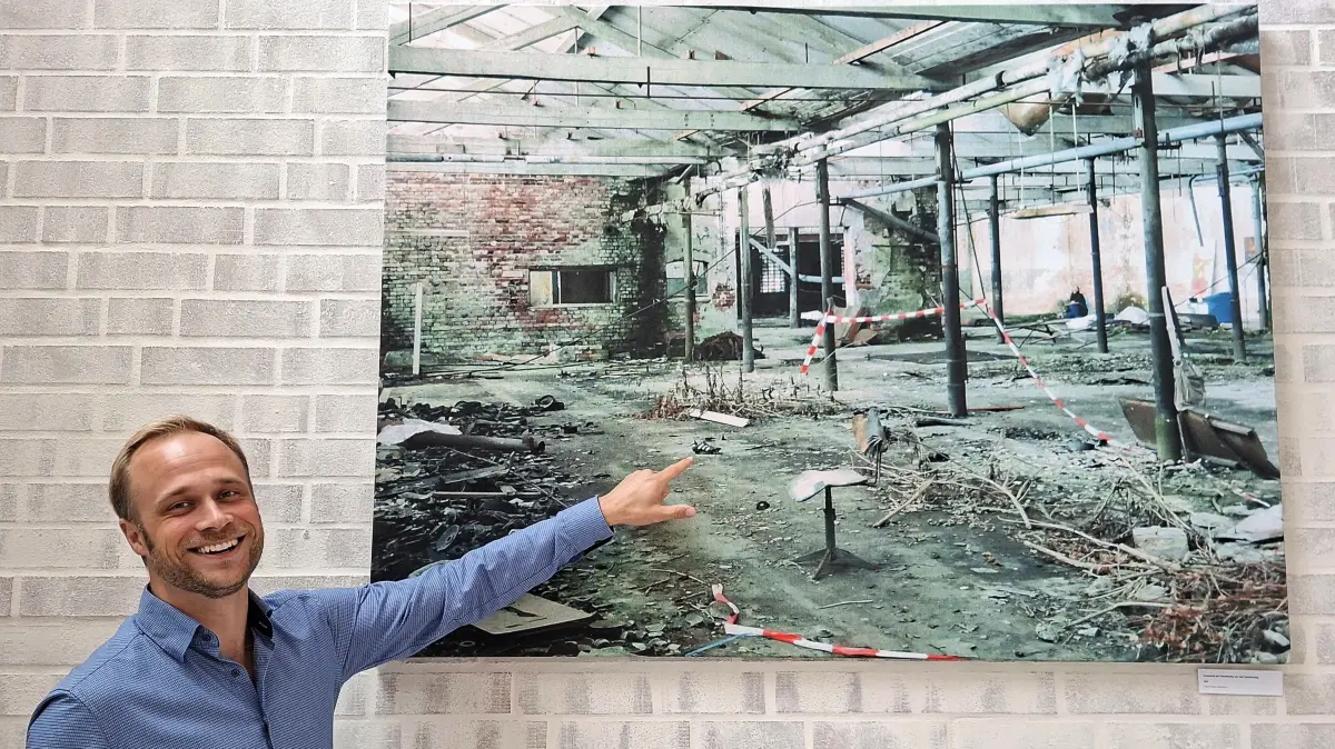 Kulturweberei Finsterwalde: So sah es noch vor wenigen Jahren in der Shedhalle, dem heutigen Saal für kleinere Veranstaltungen, für Pausengestaltung und private Feiern, aus. Jonas Gallin zeigt eine Fotografie von Architekt Jürgen Habermann.