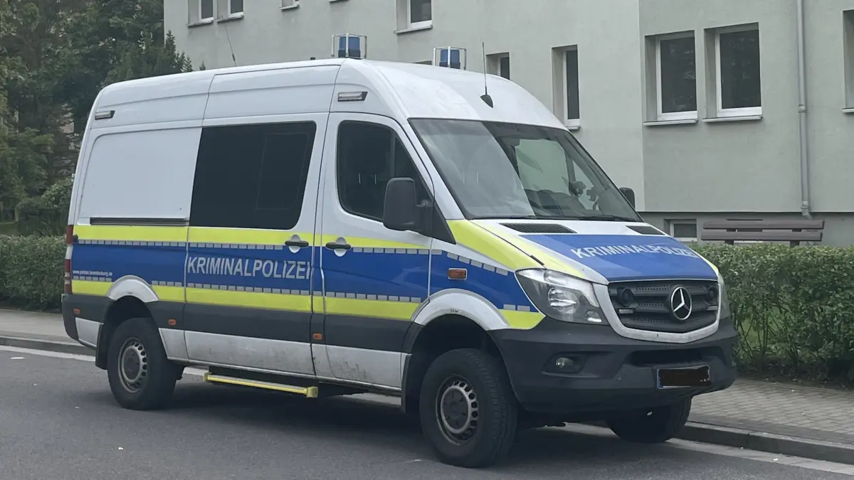 Ein Einsatzfahrzeug der Kripo steht vor einem Wohnblock in der Thüringer Straße in Finsterwalde. Die Hintergründe zum Einsatz.