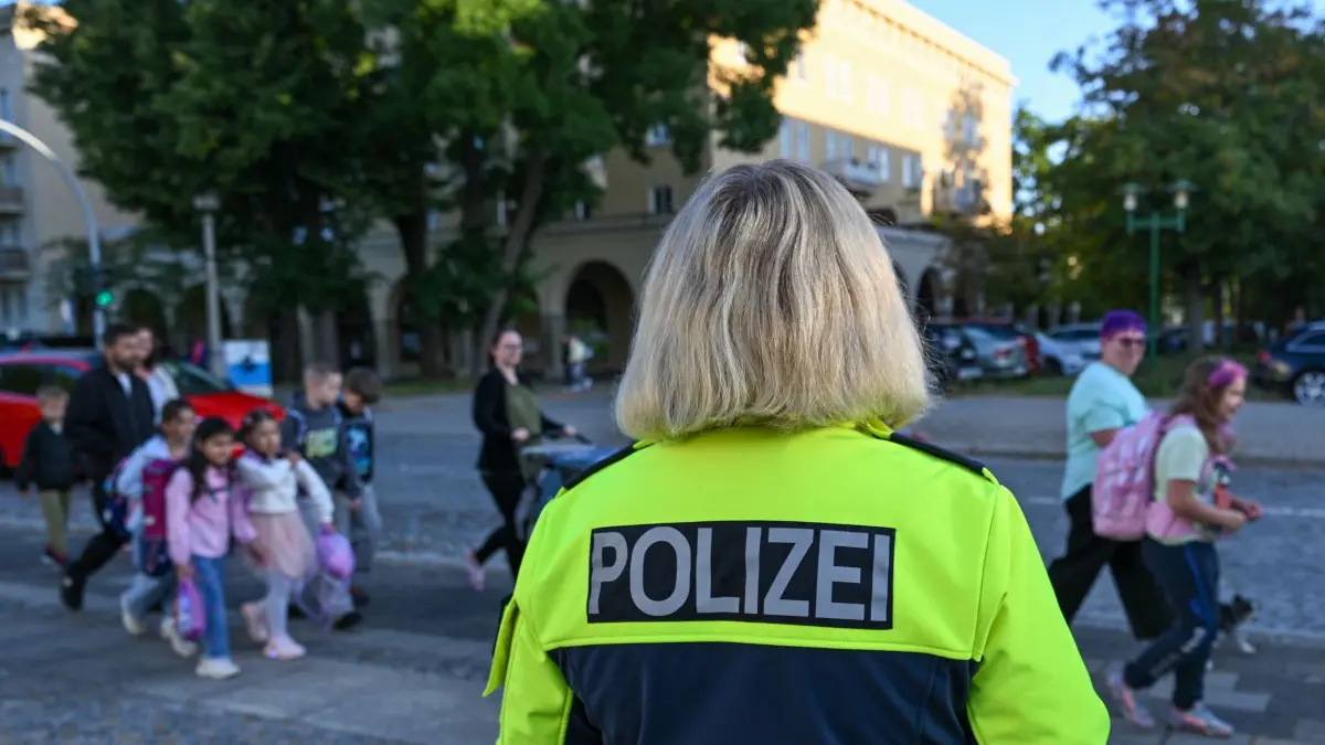 Erster Schultag nach den Sommerferien in Berlin und Brandenburg: 24.08.2026, Brandenburg, Eisenhüttenstadt: Anja Triepler, Polizeihauptkommissarin, steht am frühen Morgen, zum ersten Schultag nach den Sommerferien in Berlin und Brandenburg, vor der Erich-Weinert-Grundschule. Berlin und Brandenburg starten mit Rekordzahlen von Schülerinnen und Schülern ins neue Schuljahr. Foto: Patrick Pleul/dpa +++ dpa-Bildfunk +++