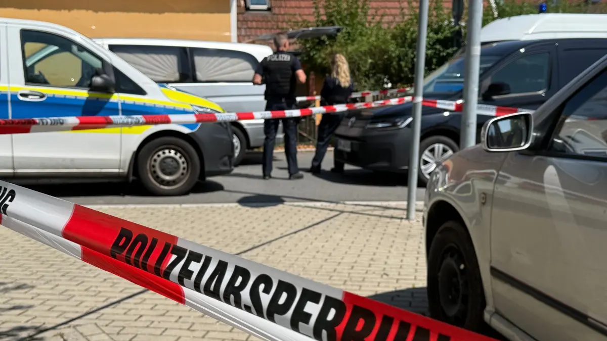 Fund von zwei Toten in Südbrandenburg: ARCHIV - 25.07.2026, Brandenburg, Ortrand: Einsatzkräfte der Polizei stehen hinter Absperrband vor einem Haus. (zu dpa: «Verdächtiger nach Fund zweier Leichen in Untersuchungshaft») Foto: Andreas Richter/dpa +++ dpa-Bildfunk +++
