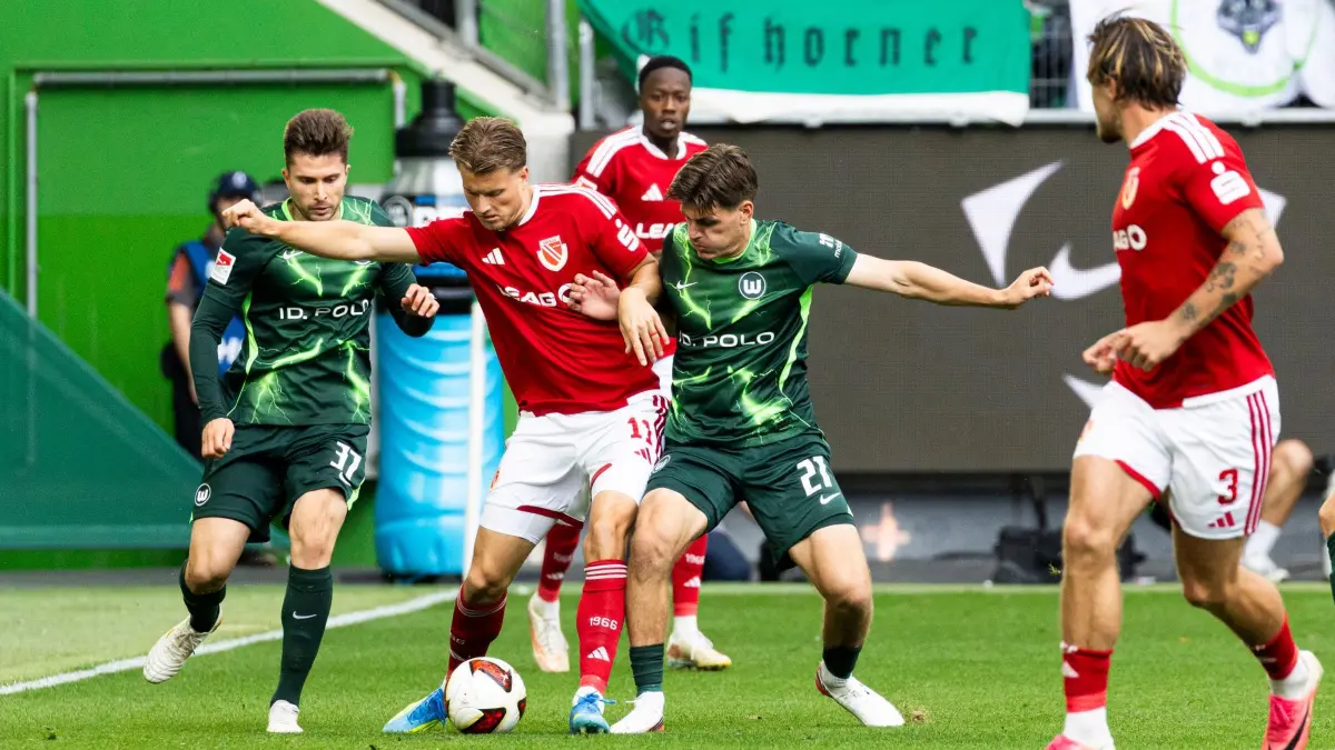 VfL Wolfsburg - Energie Cottbus: 05.09.2026, Niedersachsen, Wolfsburg: Fußball, Männer, 2. Bundesliga, VfL Wolfsburg - Energie Cottbus, 4. Spieltag, Volkswagen Arena. Moritz Hannemann (2.v.l, Energie Cottbus) im Kampf um den Ball mit Elvis Rexhbecaj (l, VfL Wolfsburg) und Joakim Maehle (3.v.l, VfL Wolfsburg). Foto: Michael Matthey/dpa - WICHTIGER HINWEIS: Gemäß den Vorgaben der Bundesliga bzw. des DFB Deutscher Fußball-Bund ist es untersagt, in dem Stadion und/oder vom Spiel angefertigte Fotoaufnahmen in Form von Sequenzbildern und/oder videoähnlichen Fotostrecken zu verwerten bzw. verwerten zu lassen. +++ dpa-Bildfunk +++