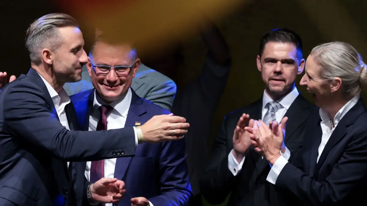 GERMANY-POLITICS-VOTE-STATE-SAXONY-ANHALT: Ulrich Siegmund (L), far-right Alternative for Germany (AfD)'s main candidate in the Saxony-Anhalt state election, reacts with AfD co-leaders Alice Weidel (R) and Tino Chrupalla (2ndL) at the AfD's election party following Saxony-Anhalt's state elections in Magdeburg, eastern Germany on September 6, 2026. Germany's far-right AfD won a landslide victory in a key regional election on September 6 in the ex-communist east, according to exit polls, but it remain unclear whether it can win an absolute majority to govern. (Photo by Ronny HARTMANN / AFP)