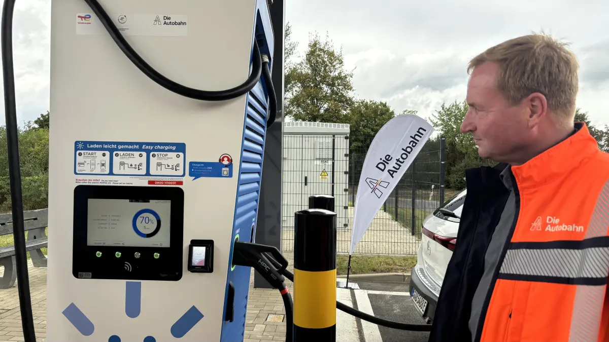 Ulf Kaulbarsch, Projektleiter der Autobahn GmbH, bei der Eröffnung des Schnellladeparks an der Raststätte Wiesenholz West bei Thiendorf, neben einer Ladesäule.