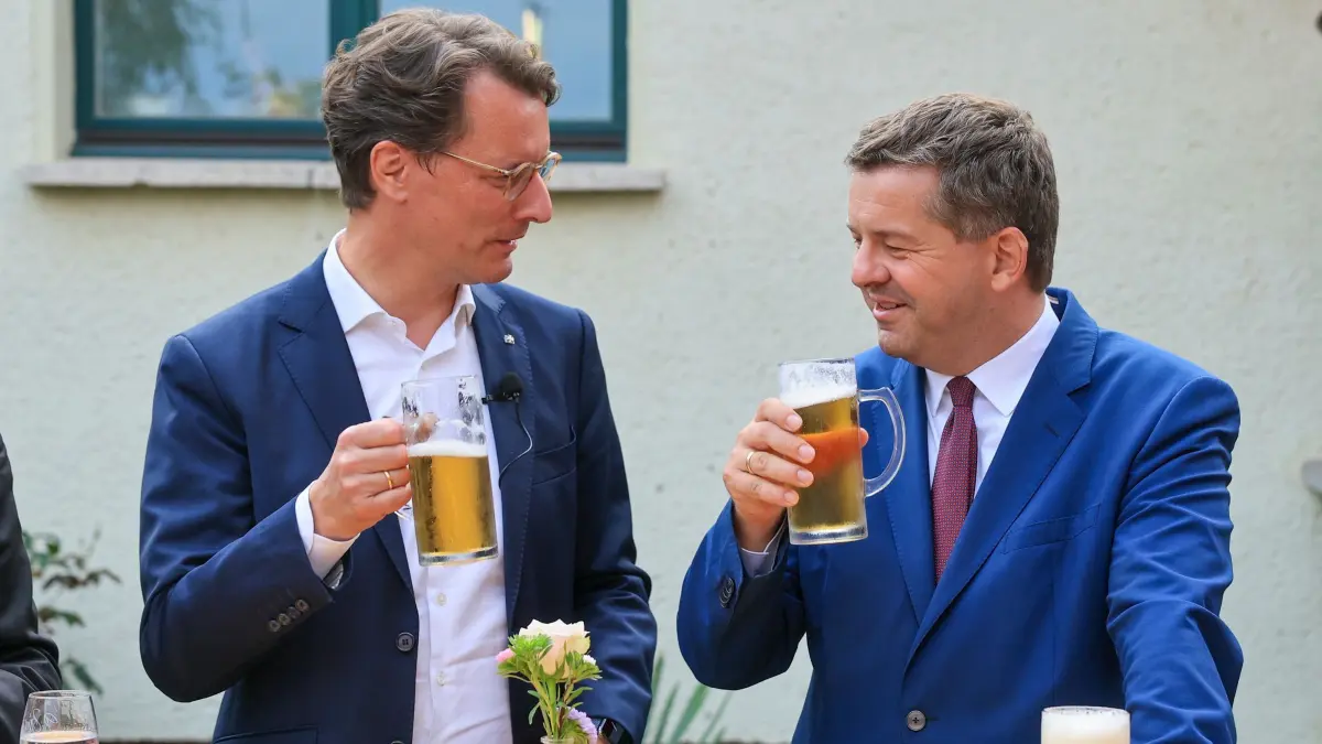 Wüst und Schulze: ARCHIV - 01.09.2026, Sachsen-Anhalt, Teutschenthal: Hendrik Wüst (l, beide CDU), Ministerpräsident von Nordrhein-Westfalen, und Sven Schulze, Ministerpräsident von Sachsen-Anhalt, stoßen während eines Bürgergesprächs mit Bier an. (zu dpa: «Hessens Regierungschef sieht mögliche AfD-Prüfung skeptisch») Foto: Jan Woitas/dpa +++ dpa-Bildfunk +++