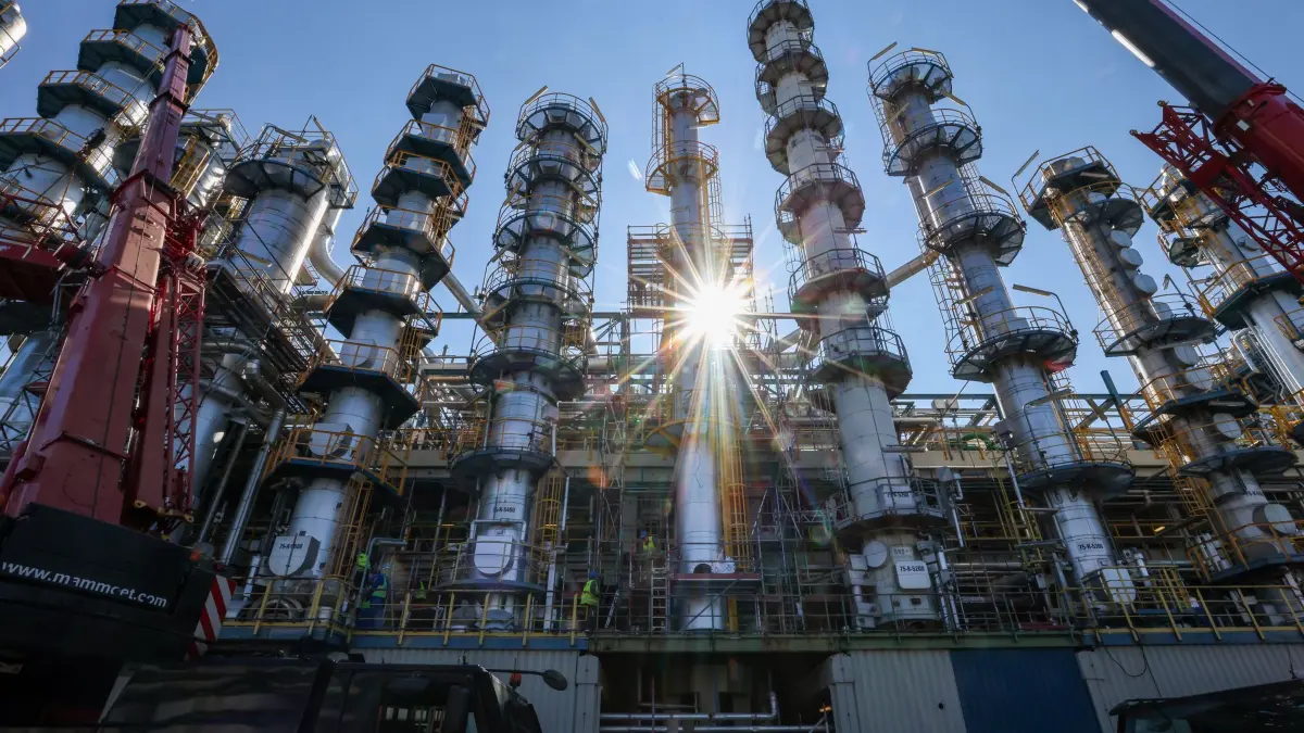 Forschungsgipfel zur Zukunft der Chemieindustrie: ARCHIV - 15.09.2023, Sachsen-Anhalt, Leuna: Die Sonne scheint hinter einer 26 Meter hohen Kolonne zur Phenolherstellung bei einem Unternehmen. (Symbolbild) (zu dpa: «Forschende beraten über Zukunft der Chemieindustrie») Foto: Jan Woitas/dpa +++ dpa-Bildfunk +++
