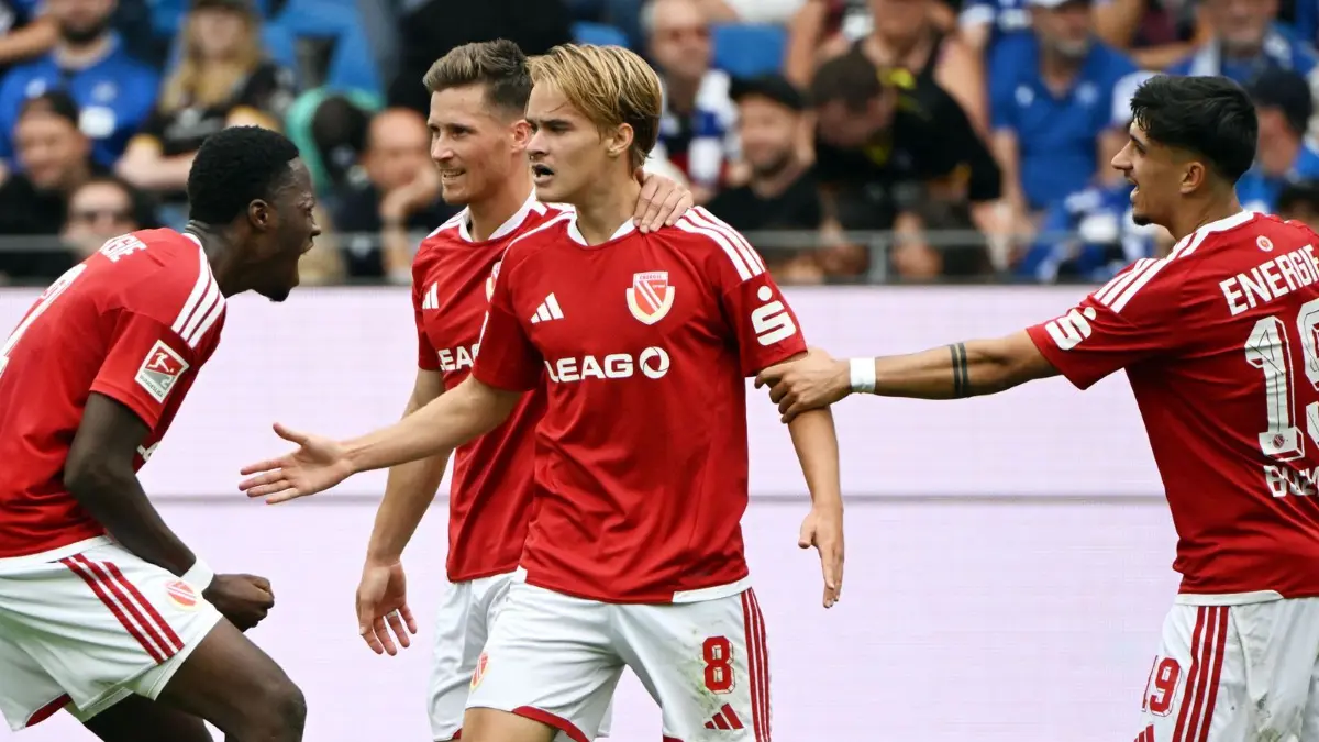 Karlsruher SC - Energie Cottbus: 13.09.2026, Baden-Württemberg, Karlsruhe: Fußball, Männer, 2. Bundesliga, 5. Spieltag, Karlsruher SC - Energie Cottbus, BBBank Wildpark: Die Cotbuser bejubeln den Treffer zum 0:1 durch Lukas Michelbrink (M). Foto: Uli Deck/dpa - WICHTIGER HINWEIS: Gemäß den Vorgaben der Bundesliga bzw. des DFB Deutscher Fußball-Bund ist es untersagt, in dem Stadion und/oder vom Spiel angefertigte Fotoaufnahmen in Form von Sequenzbildern und/oder videoähnlichen Fotostrecken zu verwerten bzw. verwerten zu lassen. +++ dpa-Bildfunk +++
