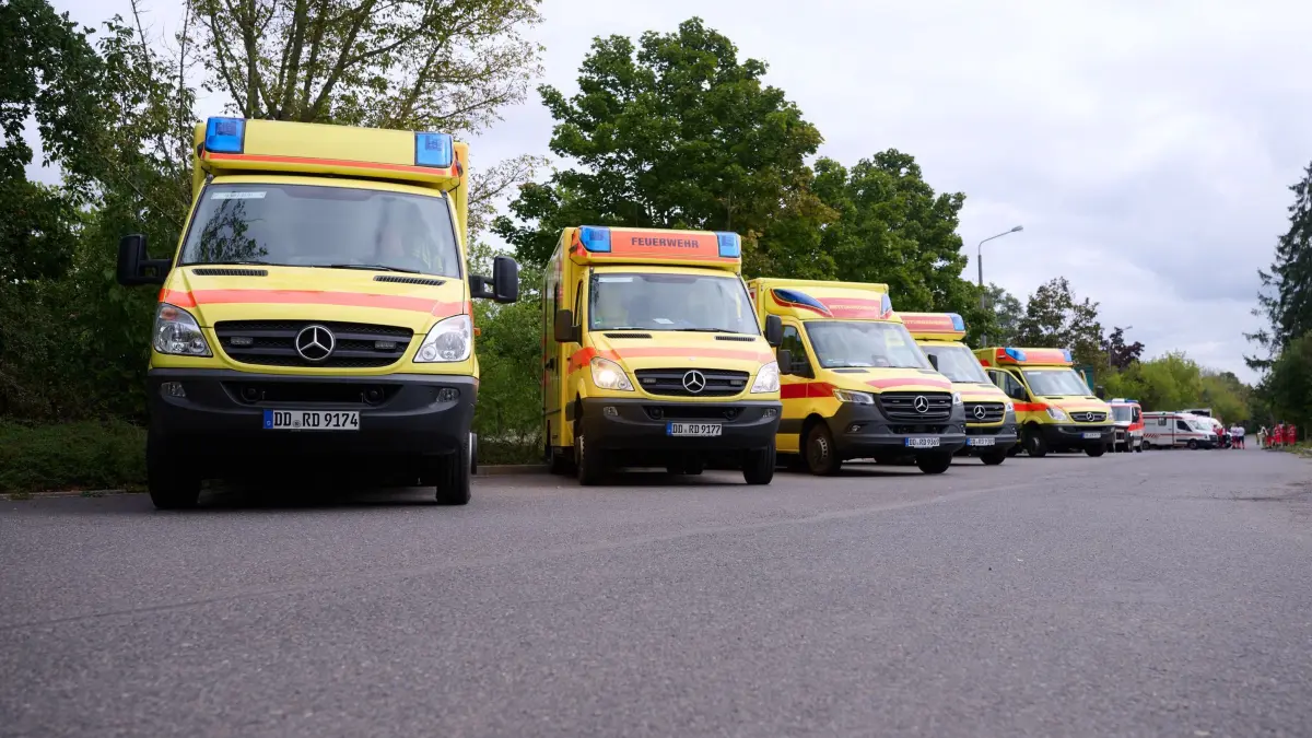 Schulgebäude in Dresden evakuiert: 14.09.2026, Sachsen, Dresden: Einsatzwagen sind vor einem Schulgelände in Dresden zu sehen. An einer Dresdner Schule lief ein Großeinsatz, nachdem zahlreiche Schülerinnen und Schüler über Reizhusten geklagt hatten. Foto: Katharina Kausche/dpa +++ dpa-Bildfunk +++
