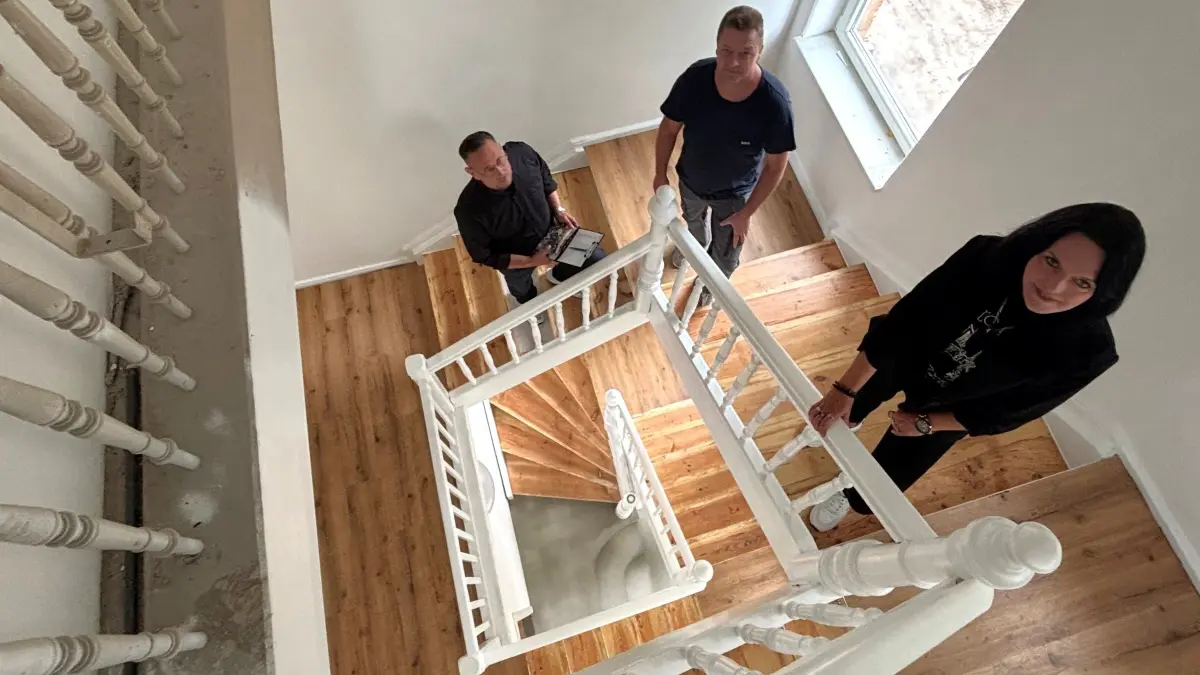 Im ersten Hausteil mit der Nummer 2a in der Von-Delius-Straße in Plessa erinnert nach der Komplettsanierung nichts mehr an den Altbau aus den 1930er-Jahren. Vielleicht noch das restaurierte Geländer im Treppenhaus. Im Bild: Katja Breite, Inhaberin der SKB Immobilien Gröditz, Bauleiter Mario Mühlbach und Swen Breite von SKB.