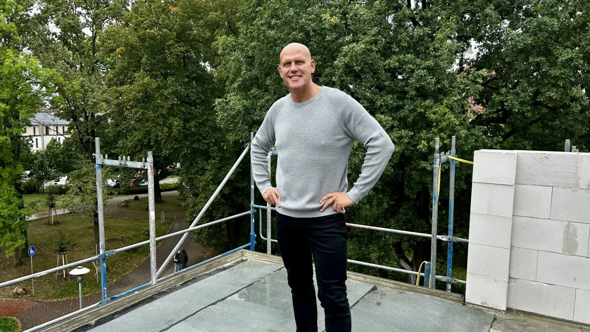 Unternehmer Veit Burmeister steht auf der Terrasse seiner Baustelle Am Fließ und genießt die Aussicht.