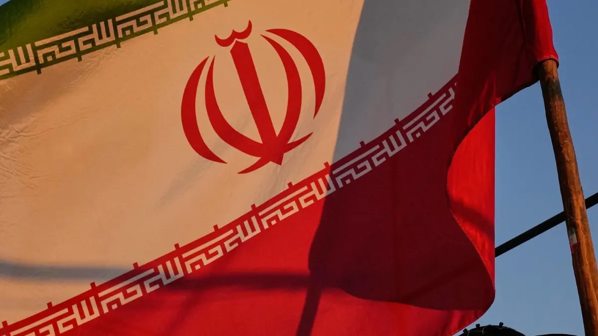 Iran-Krieg - Teheran: 15.09.2026, Iran, Teheran: Eine junge Frau hält im Rahmen einer regierungsfreundlichen Kundgebung in der Innenstadt eine iranische Flagge in der Hand. Foto: Vahid Salemi/AP/dpa +++ dpa-Bildfunk +++