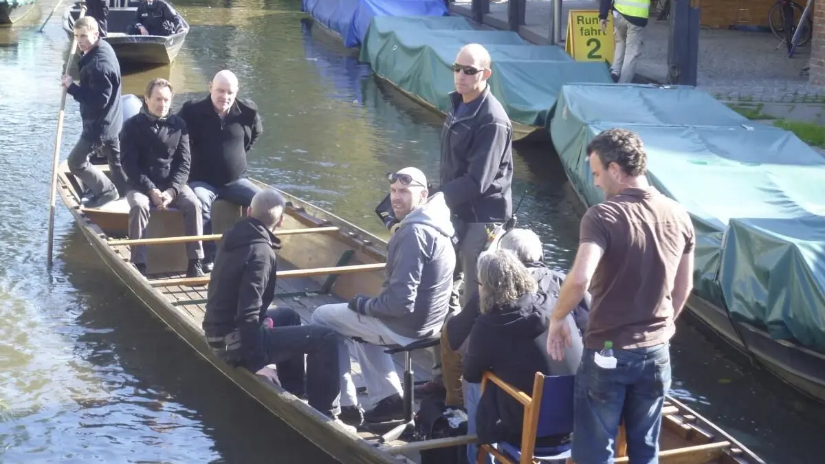 Uwe Kockisch (l.) und Christian Redl gemeinsam mit dem Filmteam im Kahn beim Showdown am Mühlenwehr in Lübbenau.