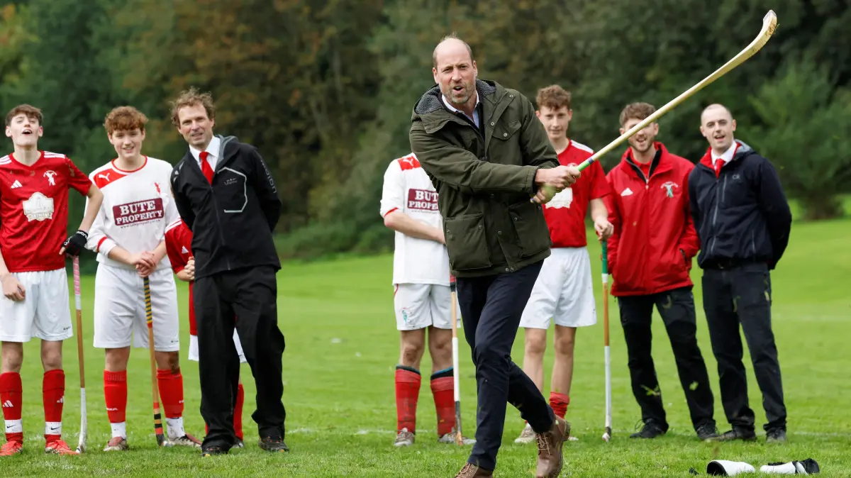 BRITAIN-SCOTLAND-ROYALS: Britain's Prince William (C), Prince of Wales, participates in the sport on the pitch while visiting Bute Shinty Club in Rothesay, in the Isle of Bute, Scotland, on September 17, 2026. (Photo by Jeff J Mitchell / POOL / AFP)