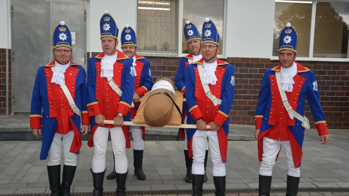 Die Langen Kerls aus Spremberg tragen schwer an der Riesen-Salami der Fleischerei Kadach. Am 3. Oktober 2026 geht es in der Stadt an der Spree wieder um die Wurst. Die Genusshandwerker feiern mit ihren Kunden.