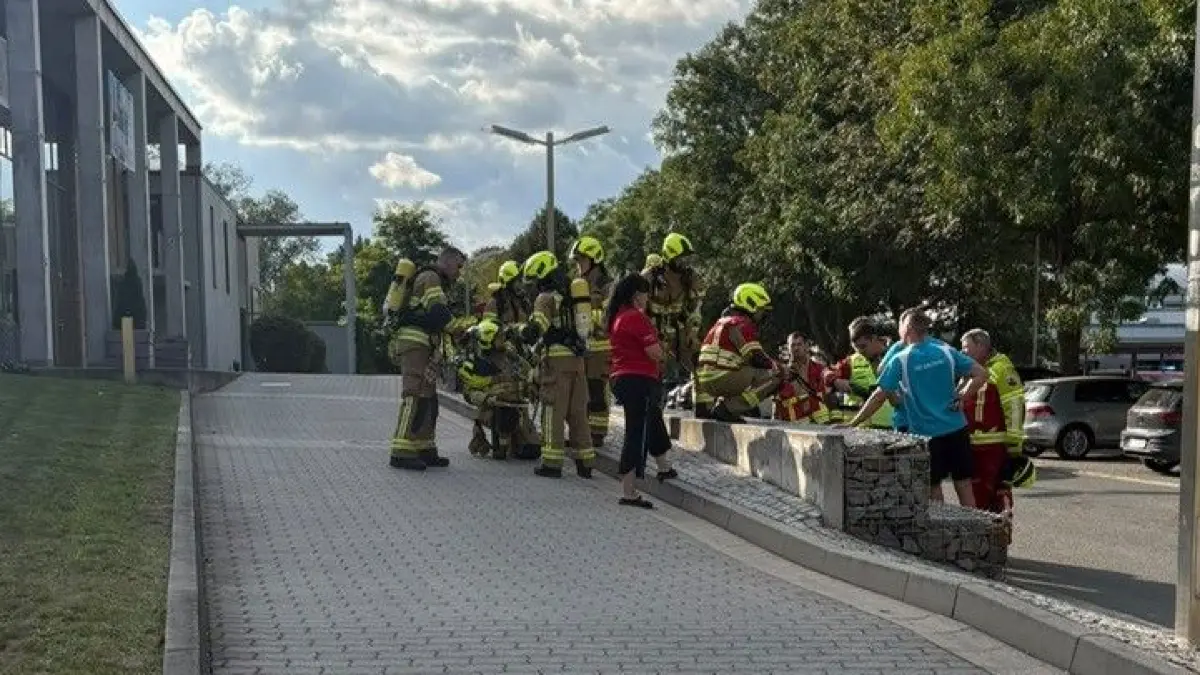 Die Einsatzkräfte der Feuerwehr bei der Lagebesprechung vor der Schwimmhalle „Fiwave“ von Finsterwalde.
