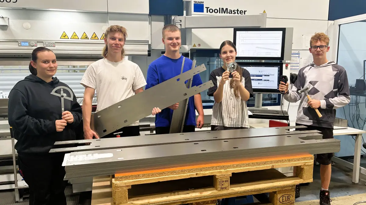 Beim Rundgang durch die REISS-Produktionshalle in Bad Liebenwerda wird bereits Material und Werkzeug an der Abkantpresse untersucht, v.l.: Lana Grunwald (Fachlageristin), Timo Röpke (duales Studium zum Bachelor of Engineering mit Industriemechaniker-Ausbildung), Fabian Hofmann (Kaufmann für Büromanagement), Sarah Mai (Fachpraktikerin) und Toni Hoffmann (Industriemechaniker).
