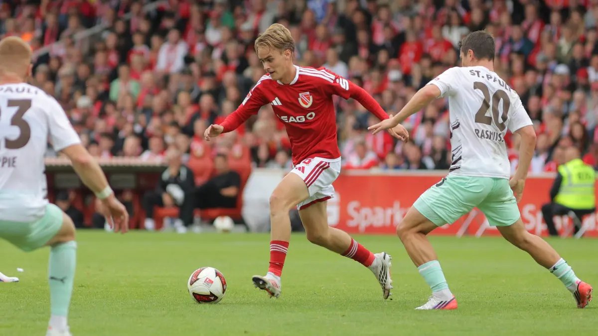 Fussball 2. Bundesliga 2026/2027 FC Energie Cottbus - FC St. Pauli: 8 Lukas Michelbrink (Energie Cottbus, M.) verfolgt von 20 Mathias Rasmussen (St. Pauli, r.)