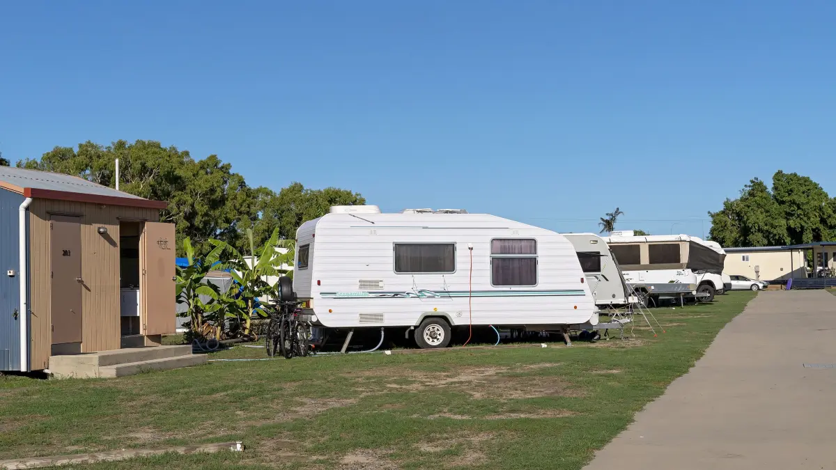 Mackay, Queensland, Australien – Dezember 2019: Wohnwagenurlauber parken in einer Reihe auf einem Touristenparkplatz; im Vordergrund befinden sich die Wohnwagen mit eigenem Bad und Dusche.