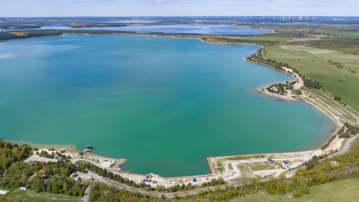 Neues Wasserrevier im Lausitzer Seenland: Blick auf den Partwitzer See (vorn) und und Sedlitzer See. Mit der Eröffnung des schiffbaren Seenverbundes am 29. Juni 2026 wachsen fünf große Seen erstmals zu einem zusammenhängenden Wasserrevier im Lausitzer Seenland zusammen. (Luftaufnahme mit Drohne). (zu dpa: «Center Parcs plant großen Ferienpark im Lausitzer Seenland»)