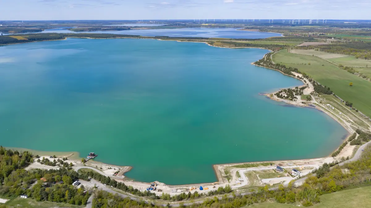 Neues Wasserrevier im Lausitzer Seenland: ARCHIV - 30.04.2026, Sachsen, Klein Partwitz: Blick auf den Partwitzer See (vorn) und und Sedlitzer See. Mit der Eröffnung des schiffbaren Seenverbundes am 29. Juni 2026 wachsen fünf große Seen erstmals zu einem zusammenhängenden Wasserrevier im Lausitzer Seenland zusammen. (Luftaufnahme mit Drohne). (zu dpa: «Center Parcs plant großen Ferienpark im Lausitzer Seenland») Foto: Robert Michael/dpa +++ dpa-Bildfunk +++