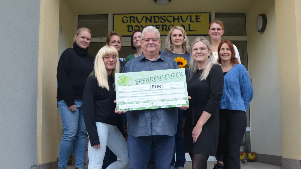 Boxberger Lehrer der Grundschule "Lernoase" übergeben an den Verantwortlichen des Freibads Reichwalde, Matthias Reißmann (m.v.), den symbolischen Spendenscheck.