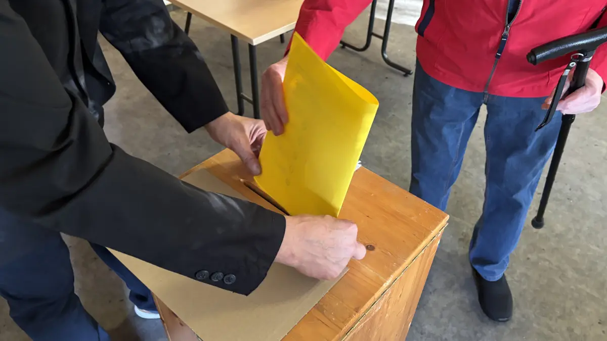 Ein Wahlhelfer steht immer an der Wahlurne in Bad Muskau zur Bürgermeisterwahl 2026. Damit hier der DIN‑A3-große gelbe Zettel ordnungsgemäß eingeworfen wird.