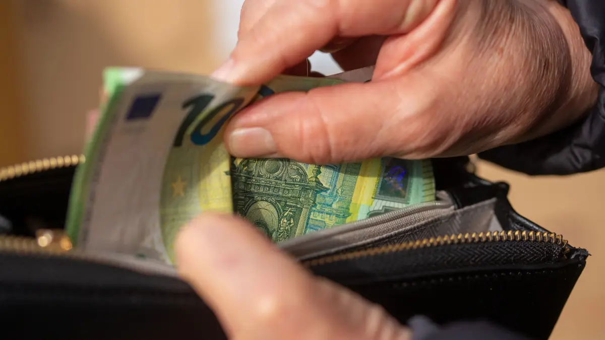 Mehr Diebstähle in Pflegeheimen: ILLUSTRATION - 24.03.2026, Berlin: Eine Seniorin steckt Euro-Banknoten in eine Geldbörse. (zu dpa: «Mehr Diebstähle in Pflegeheimen - BSW fordert Schutz») Foto: Fernando Gutierrez-Juarez/dpa +++ dpa-Bildfunk +++