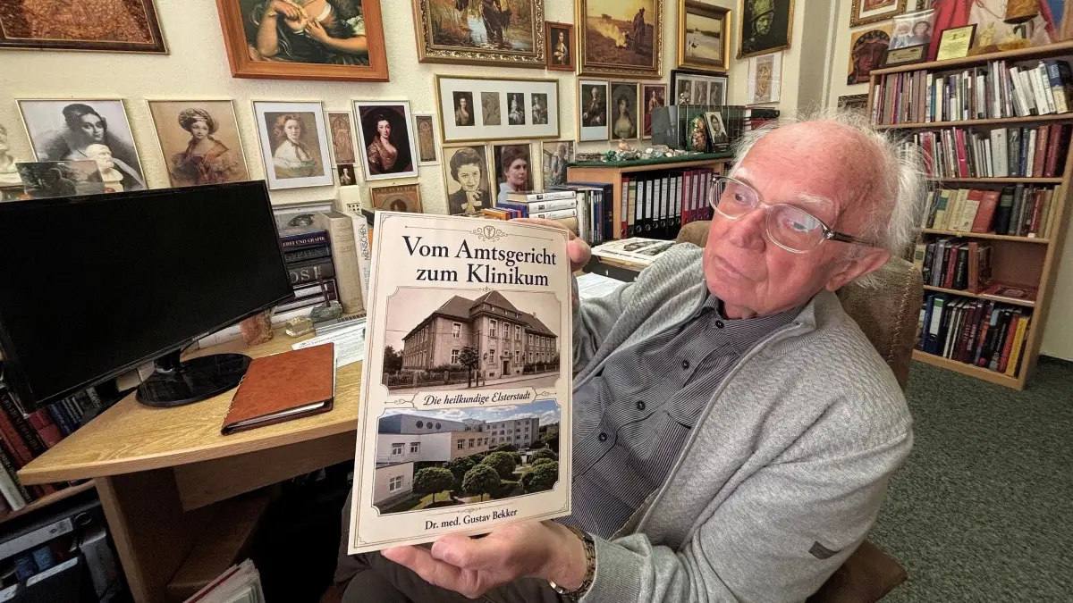 MR Dr. med. Gustav Bekker in seinem Arbeitszimmer. Er hält die fertige Chronik über die Geschichte des Krankenhauses in Elsterwerda in den Händen. Ein vollständigeres Werk gibt es nicht.