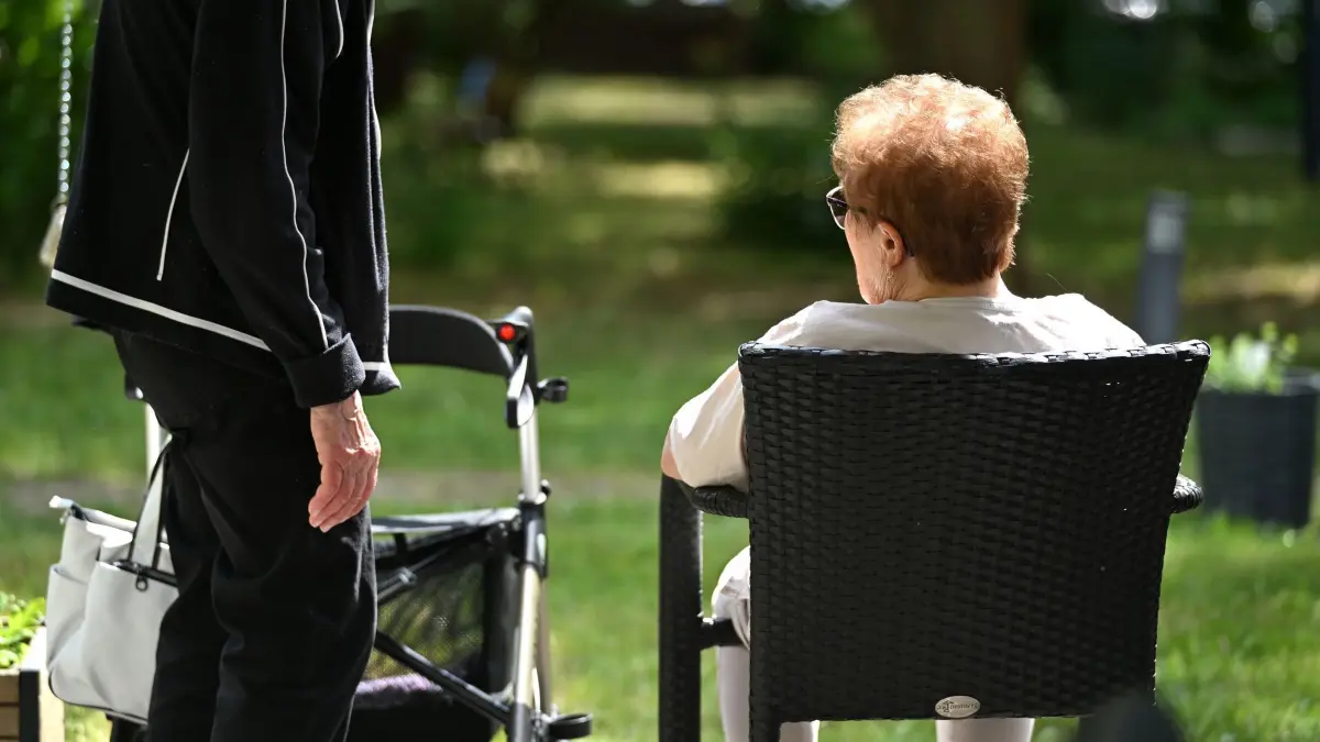 Pflegebedürftige Menschen: Zwei Senioren sprechen in dem Garten eines Pflegeheims miteinander. Hitze stellt insbesondere für ältere und pflegebedürftige Menschen ein Risiko dar. (zu dpa: «Regierung bringt Pflegereform auf den Weg»)