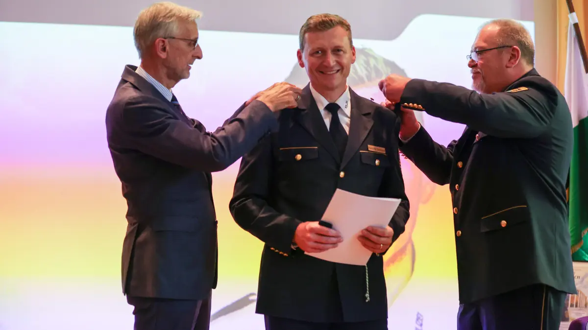 Sachsens Innenminister Armin Schuster (l.) und Vorgänger Manfred Weißbach (r.) legen gemeinsam Hendrik Schlicke die neuen Schulterstücke an.
